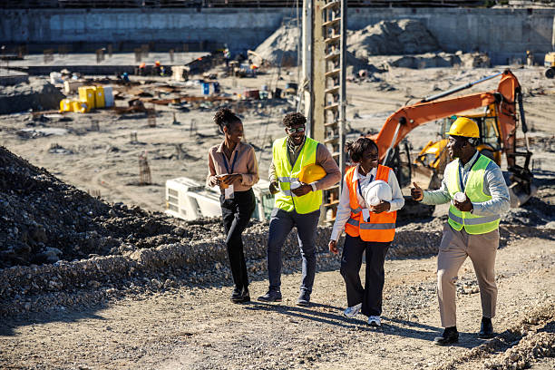 Group of diverse engineers collaborating on a new construction project, walking and talking at the building site