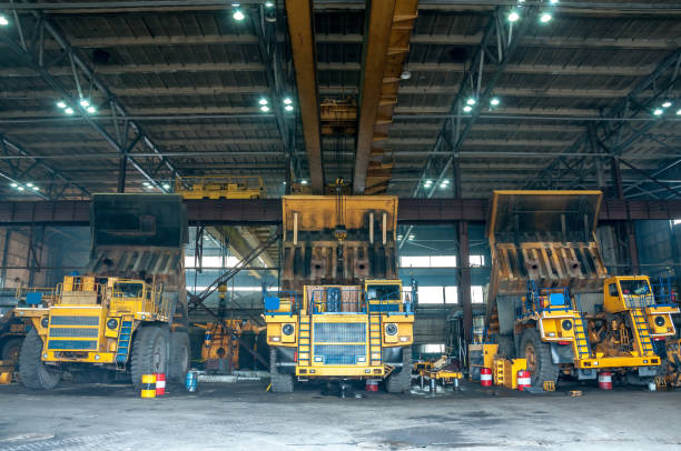 heavy yellow open cast mine dump trucks at repair station